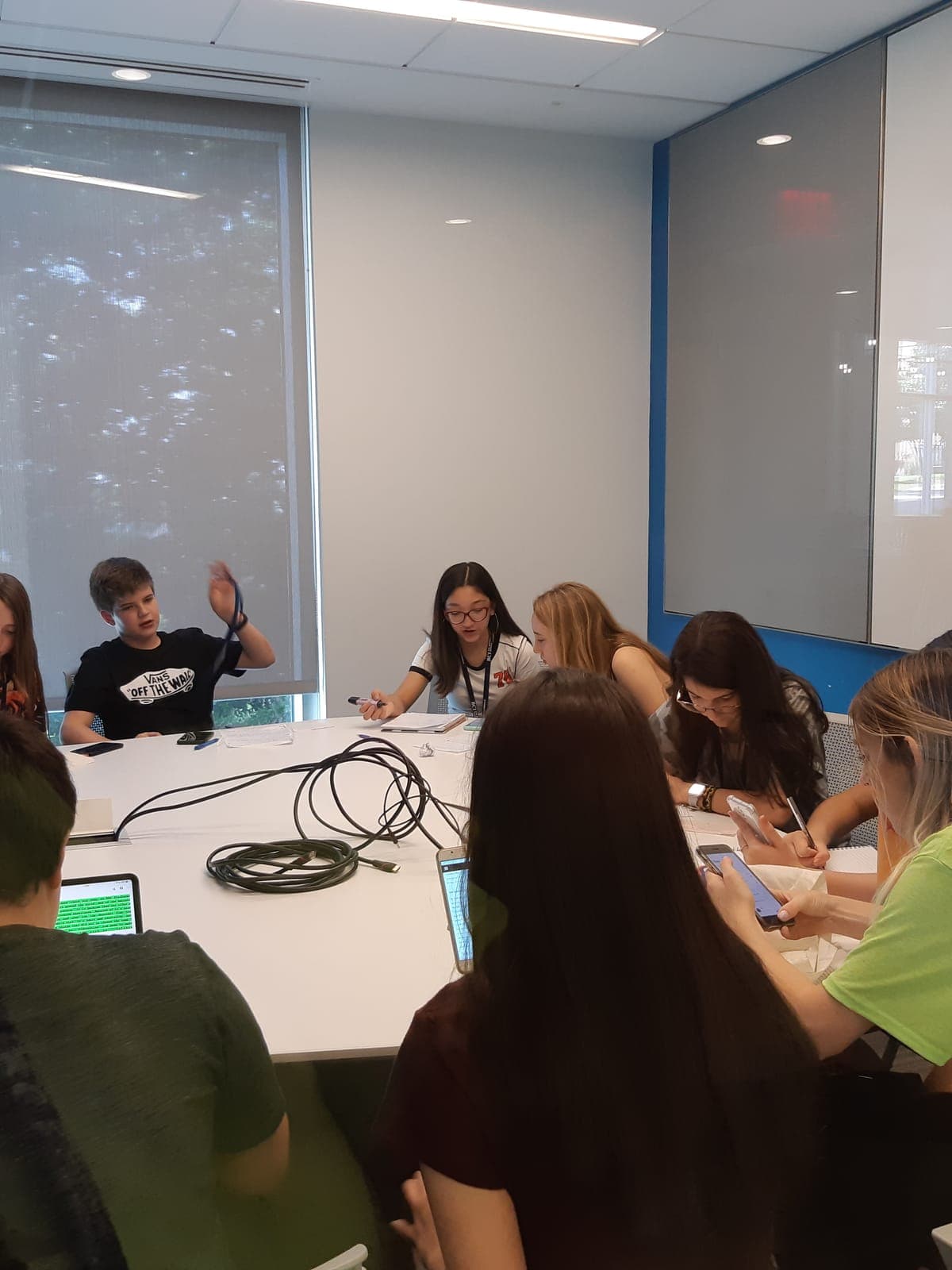 A team of participants around the meeting table, with laptops and worksheets, developing their project.