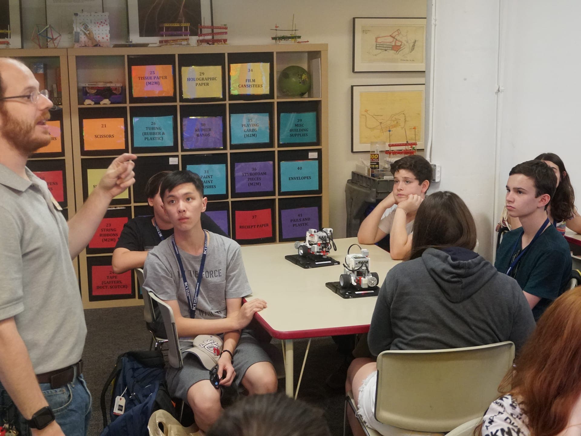 Educator explaining the class content to participants gathered around the work table.