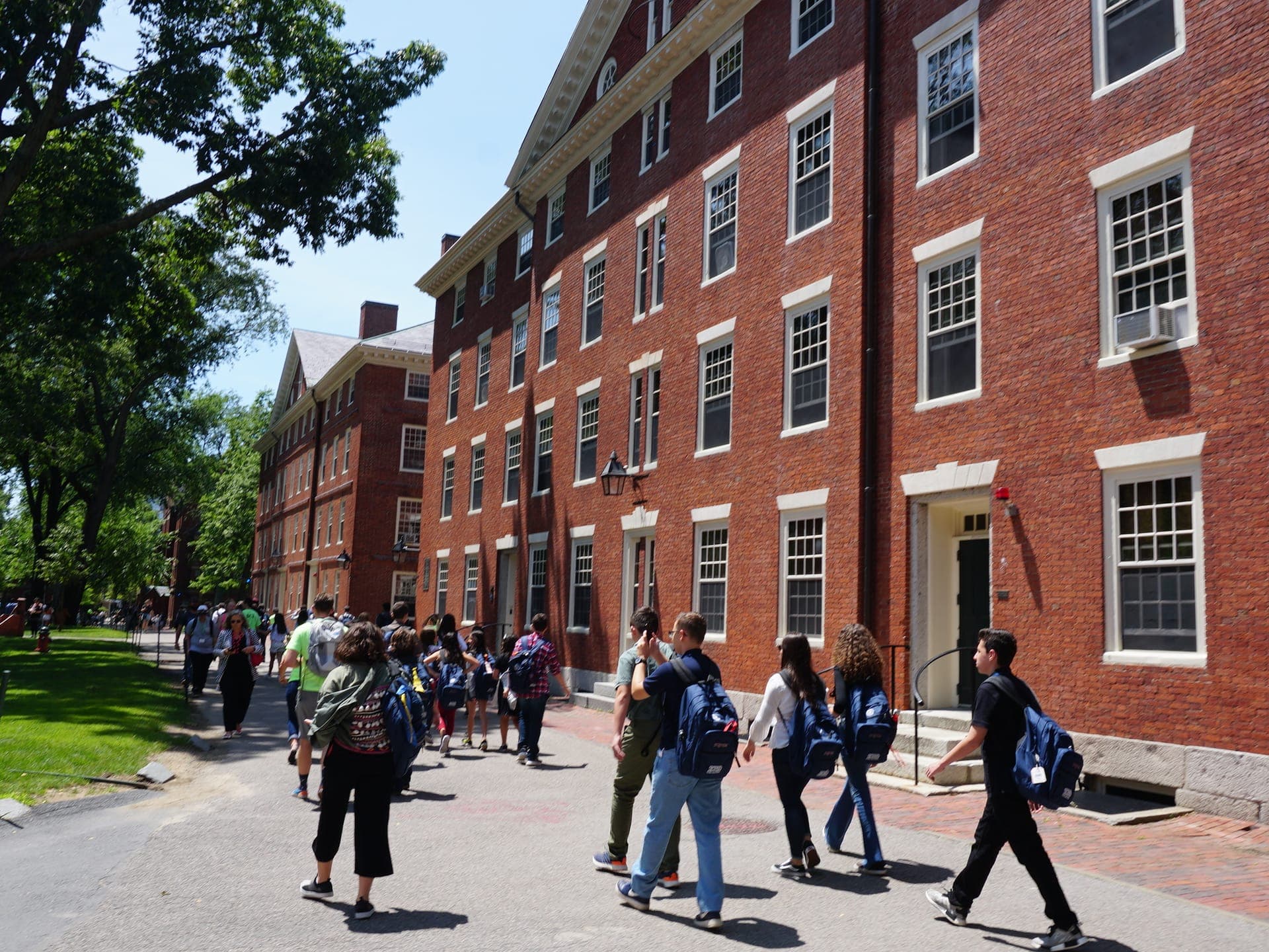 BCI group walking through Harvard Yard between the historic brick halls.
